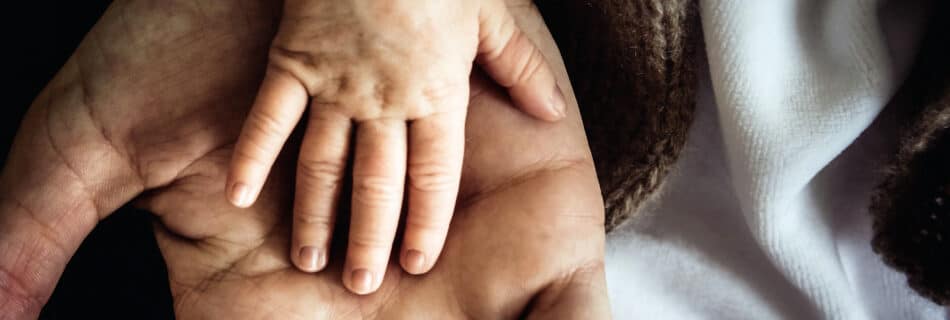 Main d'un enfant sur celle d'un adulte